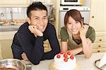 Front view of young couple celebrating with strawberry cake