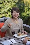 Front view of a smiling woman having food with wine