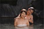 Middle-aged couple relaxing in natural hot spring