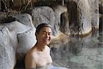 Front view of a man relaxing in natural hot spring