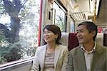 Couple looking out of the window while traveling in train