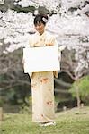 Japonaise femme debout tenant Conseil blanc
