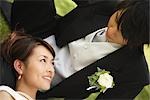 Bride and Groom Laying on Grass