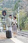 Couple waiting for train on platform