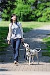 Woman and Dog Walking In Park