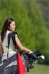 Jeune golfeuse asiatique sur le parcours de golf