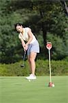 Young Asian female golfer on practice green
