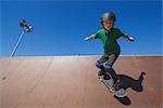 Boy jumping with skateboard in skate park