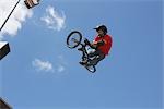 Biker sauter avec son vélo contre le ciel bleu