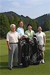 Front view of golfers standing with golf bags