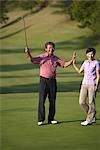 Couple high fiving each other at golf course