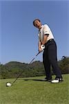 Low angle view of a golfer ready to hit golf ball