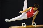 A male gymnast performing on pommel horse