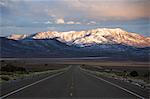 Schneebedeckte Berge auf einer geraden Straße des amerikanischen Südwesten US Route 50, die einsamste Straße in Nordamerika, Nevada, Vereinigte Staaten von Amerika,