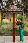 A boy using a monk decorated telephone box at Shaolin temple, birthplace of Kung Fu martial arts, Shaolin, Henan Province, China, Asia
