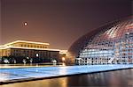 Full moon above Soviet style Great Hall of the People contrasts with The National Theatre Opera House, also known as The Egg designed by French architect Paul Andreu and made with glass and titanium opened 2007, Beijing, China, Asia