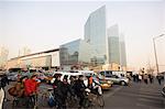 Commuters on bicycles and car drivers in the CBD business district, Guomao area, Beijing, China, Asia