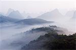 Early morning mist clinging to karst limestone scenery around Yangshuo, near Guilin, Guangxi Province, China, Asia