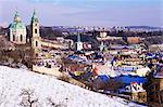 Snow covered Schonbornska Garden, Baroque St. Nicholas church and Mala Strana suburb rooftops in winter, Hradcany, Prague, Czech Republic, Europe