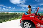 Young woman sitting on dune buggy, Pitangui, Natal, Rio Grande do Norte state, Brazil, South America