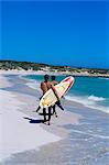 Two surfers walking with their boards on Kommetjie beach, Cape Town, South Africa, Africa