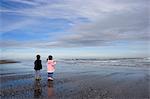 Boy aged four and girl aged three on a black volcanic sand beach in Manawatu, North Island, New Zealand, Pacific