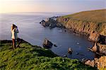 Observation des oiseaux sur les falaises de la réserve naturelle de Hermaness, regardant vers le nord vers Vesta Skerry, Tipta Skerry régurgitée, Muckle Flugga et son phare au loin, Unst, îles Shetland, Ecosse, Royaume-Uni, Europe