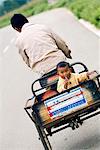 Child being carried on tricycle, Baisha, Yunnan, China, Asia