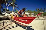Man painting outrigger boat on Boracay island, off Panay, Philippines, Southeast Asia, Asia