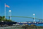The Stars and Stripes flying before the Newport Bridge, connecting Jamestown, Conanicut Island, and Aquidneck Island, Rhode Island, New England, United States of America, North America