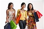 Three women holding shopping bags.