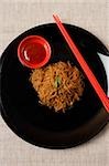 Noodles on plate with chopsticks.
