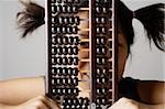 Young woman peering through abacus.