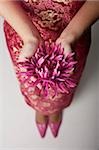 gros plan de femme portant cheongsam rose tenant une fleur pourpre