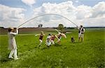 Happy family jump roping in countryside