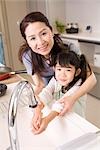 Girl washing hands with grandmother