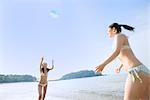 Zwei junge Frauen spielen mit Strandball