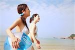 Zwei junge Frauen zu Fuß am Strand