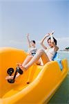 Two young women riding on pedal boat