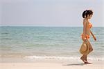 Junge Frau im Bikini am Strand zu Fuß