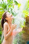 Young woman in bikini taking shower