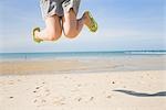 Beine junge Frau am Strand springen