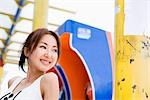 Young woman standing in front of pay phone