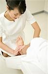 Massage therapist applying foot massage