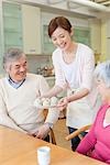 Daughter serving rice ball plate to parents