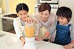 Mother and children making fresh juice