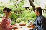 Junges Paar in Kimono mit Mittagessen im offenen café