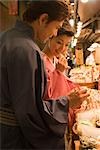 Young couple in kimono looking market