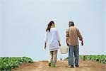 Senior couple holding bucket in field