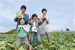 Family standing in cabbage field